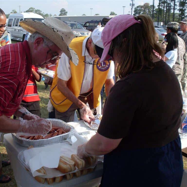 Lions Club members serving hot dogs outdoors