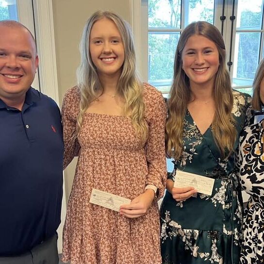 Students of the month for September and October 2023 pose with their checks