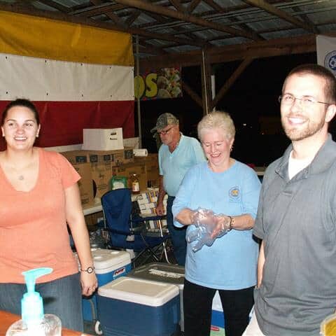 Smiling women and men behind a beverage counter