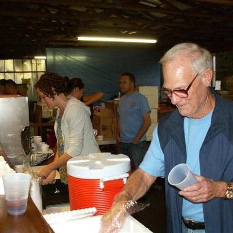 A man and woman behind a food and beverage counter