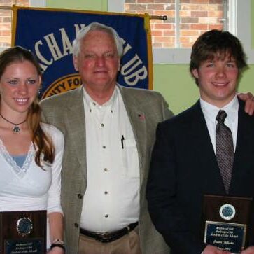 A man in a sports jacket with a young woman and a fellow male Exchange Club plaque recipient