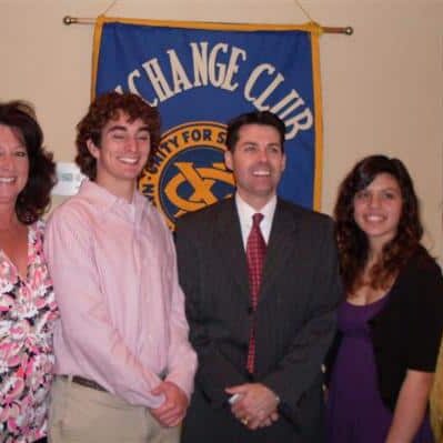 A young male and female student with their mothers and an Exchange Club presenter