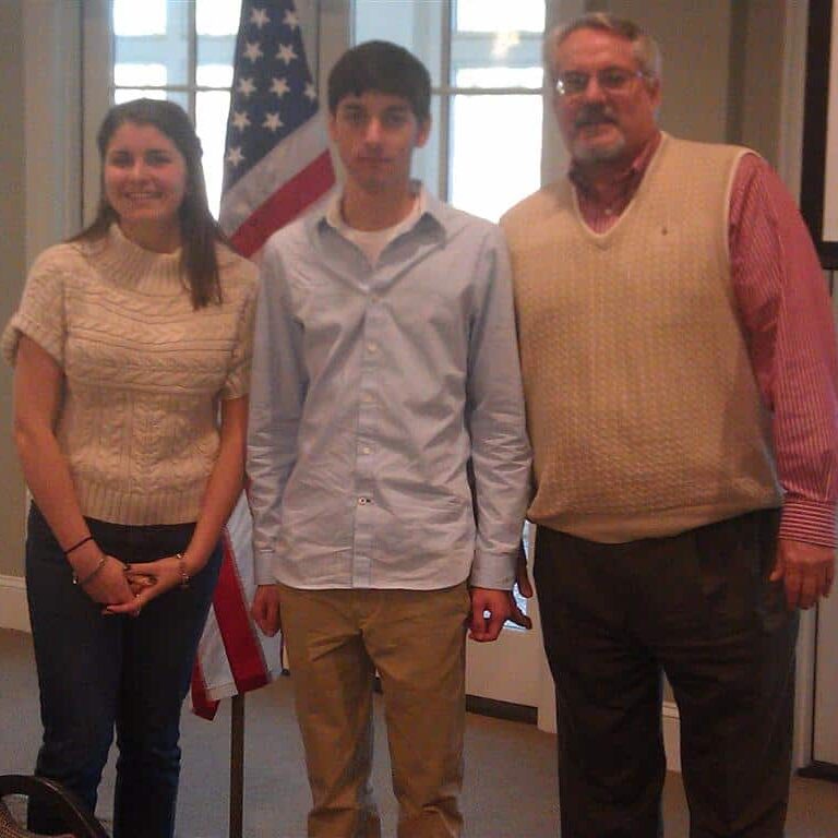 A male and female student standing next to a male Exchange Club member