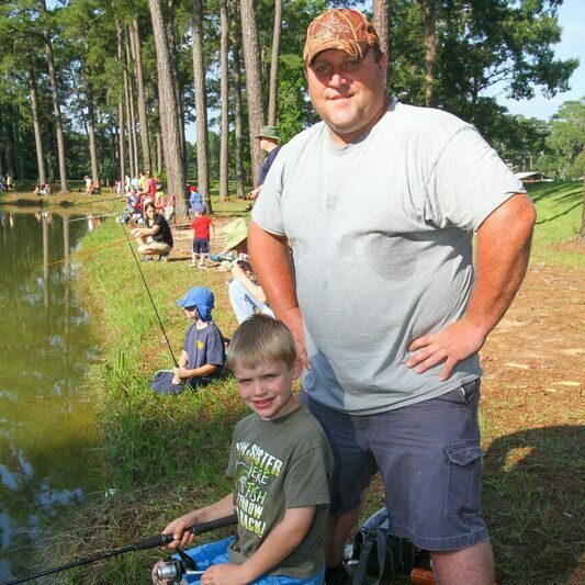 Adult and child smile and get ready to fish