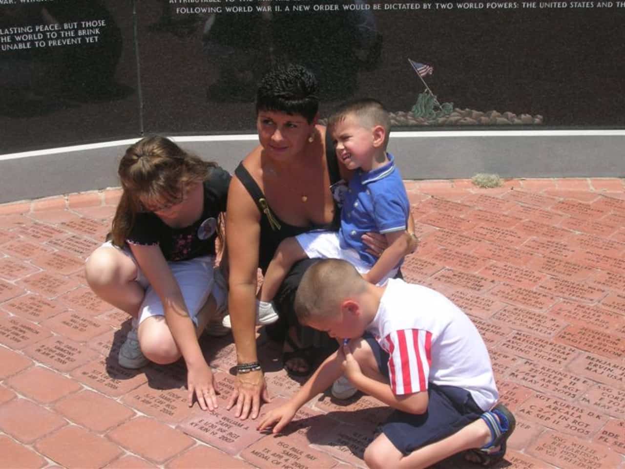 A family admires the military memorial bricks