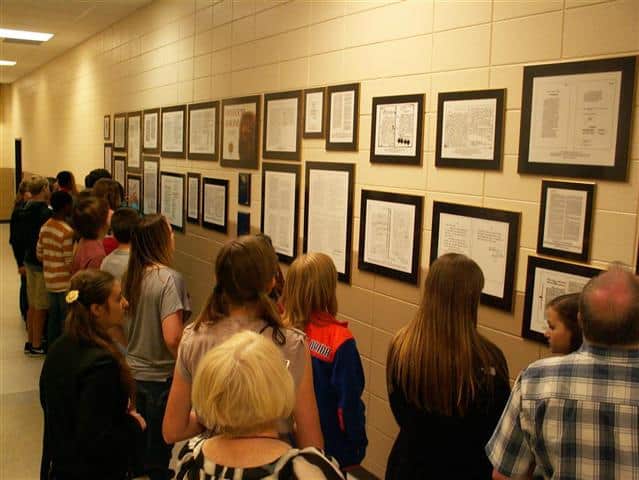 Students looking at a wall of framed documents