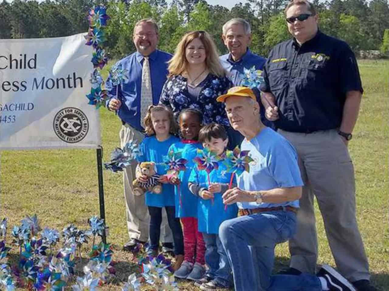 Volunteers pose with the Blue Pinwheel garden