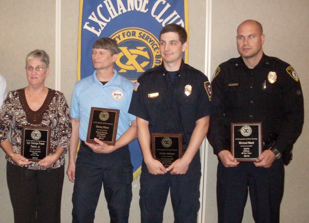 A woman and three men holding Exchange Club plaques in recognition of their safety efforts